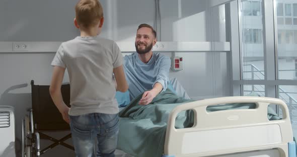 Preteen Boy Visiting Father Lying in Bed in Hospital, Stock Footage