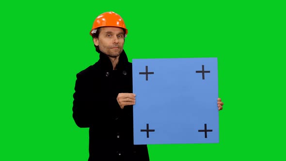 Engineer Builder In Hard Hat Holding Blue Mockup Board