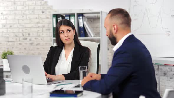 Focused Young Businesswoman and Male Businessman Discussing Planning Analyzing Business Project alt