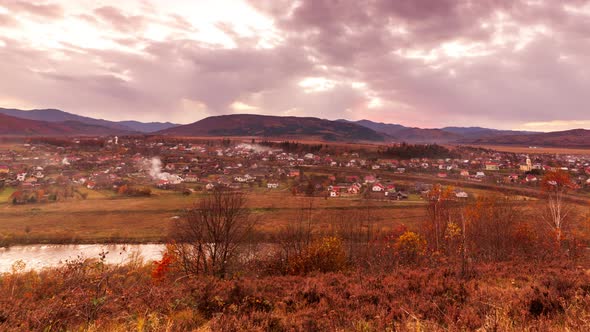 Aerial View of Village Houses in a Mountain Valley Against a Blue Sky with Occasional Clouds