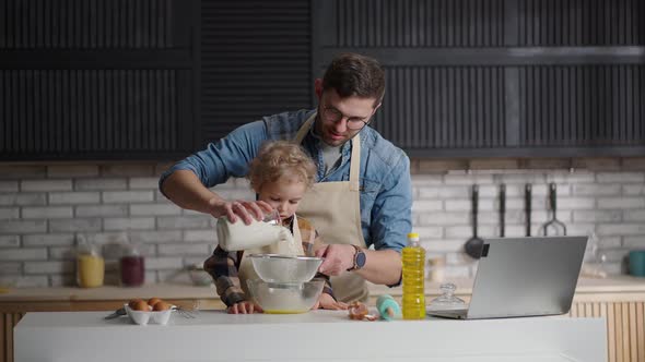 Father and Little Son are Sifting Flour for Pancake Batter Cooking Together at Home Kitchen at alt
