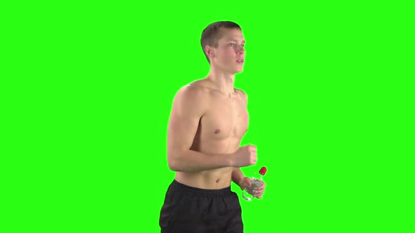 Athlete in Shorts and a Bottle of Water During Training. Green Screen. Slow Motion alt