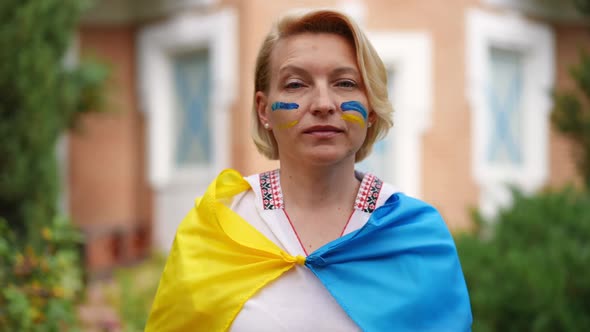 Confident Ukrainian Woman Gesturing Peace Standing on Backyard in Ukrainian Flag with Blue and alt