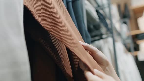 Close-up of female hands plucked hanger Choosing clothes in a clothing store