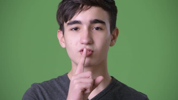 Young Handsome Iranian Teenage Boy Against Green Background alt