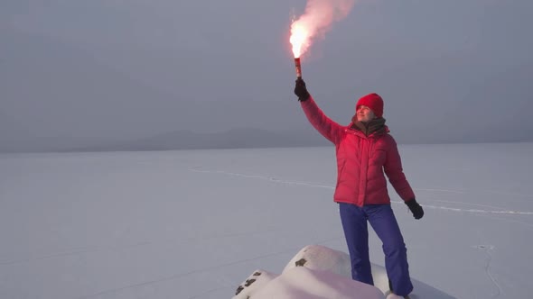 A Joyful Woman in a Winter Suit Lit and Raised the Signal Stick Up