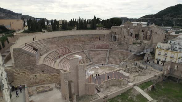 Tourists in roman amphitheater in Cartagena, Spain. Aerial forward