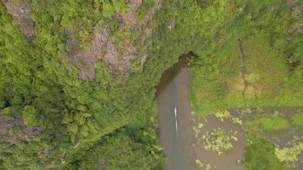 Aerial Shot of Beautiful Limestone Mountains with Passes Carved By a River in Ninh Binh Region a alt