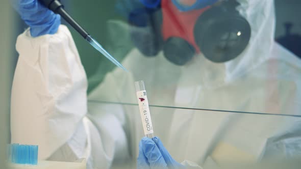 Worker Fills a Tube with Liquid in Laboratory. alt