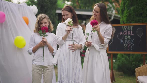 Smiling Beautiful Caucasian Women and Girl Smelling Roses in Slow Motion Standing Outdoors on alt