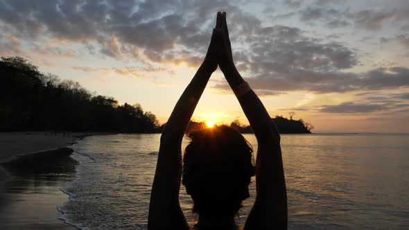 Young Girl Practicing Yoga on the Beach at Sunset