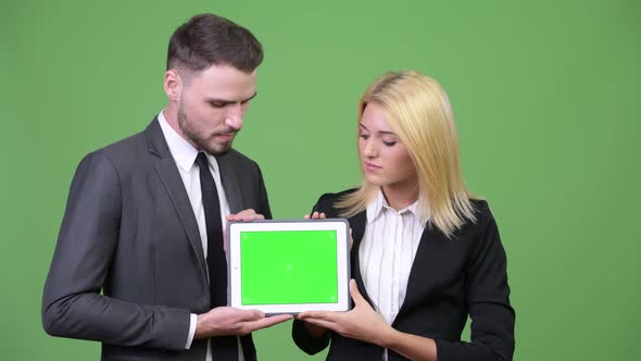 Young Happy Business Couple Showing Digital Tablet Together