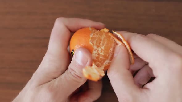 Hands of Man Peel Mandarin Close Up