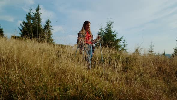 Woman Hiking with Trekking Poles in Mountains alt