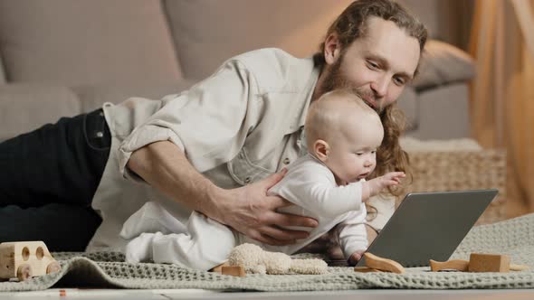 Adult Caucasian Dad Bearded Single Father with Newborn Baby Making Video Call to Mother or Relatives alt