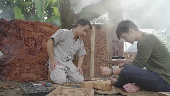 Young Man Learning To Carve Wooden To His Teacher alt
