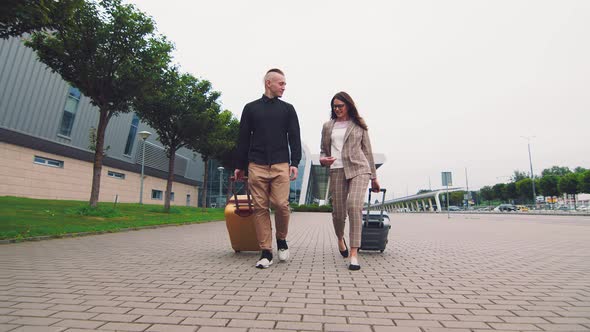 Two Young People in Love Traveling. Happy Couple Goes To the Airport Terminal with Luggage. Young alt