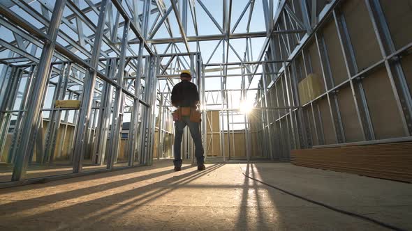 The Construction Site. Steel Frame of the Building and Contractor Worker. alt