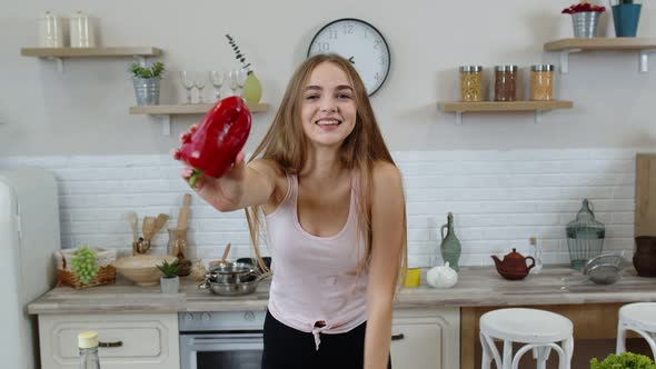 Girl Recommending Eating Raw Vegetable Food. Showing Pepper in Hands. Weight Loss and Diet Concept alt
