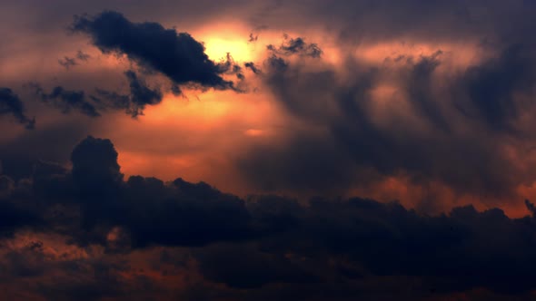 Brightly Red Cumulus Clouds Swirl at Sunset alt