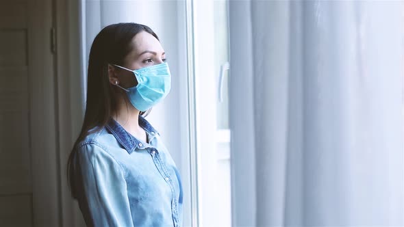 Young Caucasian Woman with Medical Mask Coming to the Window alt