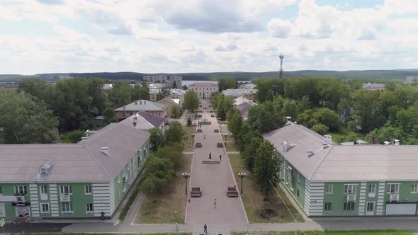 People walks along a beautiful alley in a provincial town. Poplar fluff flies 03 alt