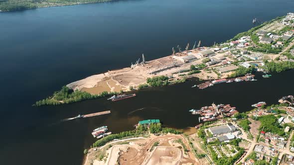 Construction Site on the River Bank, View From the Copter. Barge Sails Between the Banks, Houses on