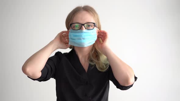 Protection Against Coronavirus. Woman Puts a Mask on Her Face.