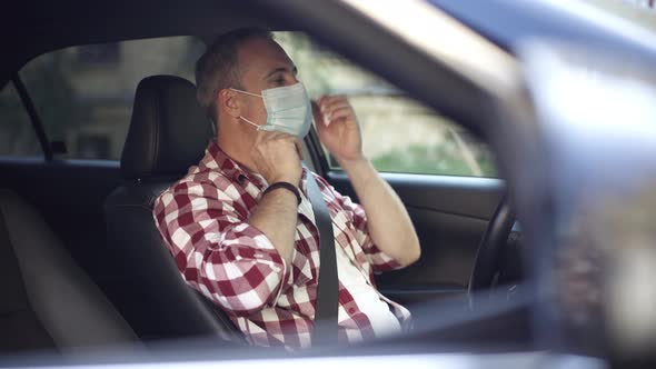 Confident Adult Man Putting on Covid19 Face Mask and Getting Out of Car alt