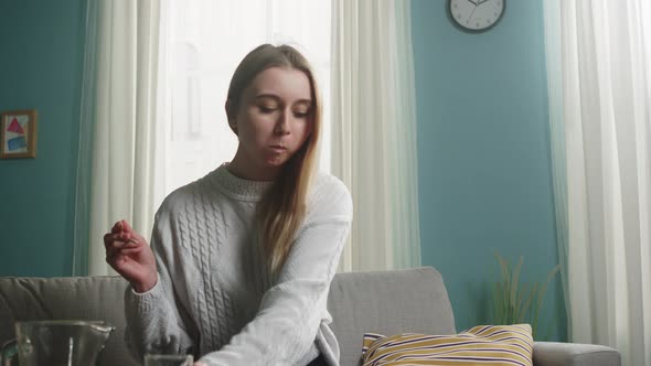 Young Girl with Blond Hair Puts a Glass and Prepares To Eat Sushi alt