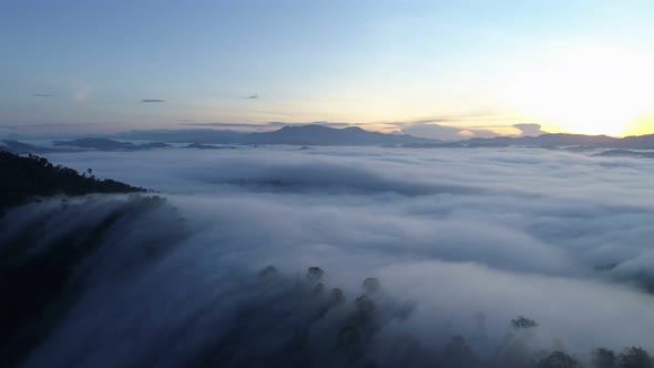 Aerial view Drone flying through the fog above mountain peak alt