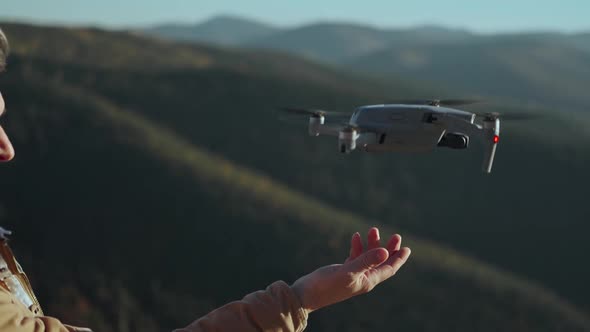 Close Up Hand of Professional Drone Operator and Aerial Photographer Landing Drone on His Hand After alt