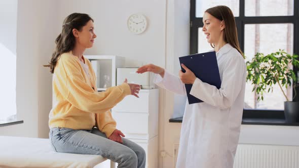 Doctor with Clipboard and Woman Meeting at Clinic