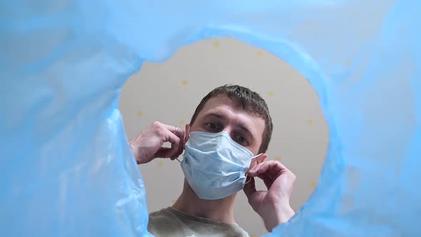 Low Angle View of a Man Throwing Disposable Medical Mask Into the Bin.