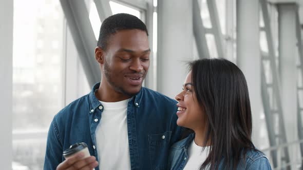 African Tourists Couple Talking And Laughing Drinking Coffee In Airport alt