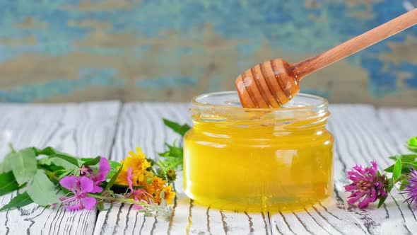 Honey in Glass Jar with Honey Dipper Over Rustic Wooden Background alt