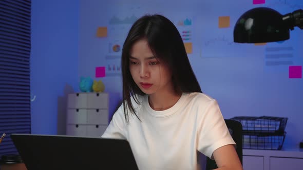 business woman working on laptop with have a headache because migraine on the office at night. alt