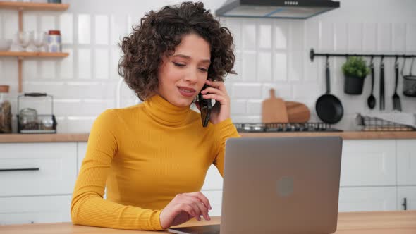 Smiling Hispanic Curly Woman Student Talking on Mobile Phone Using Laptop alt