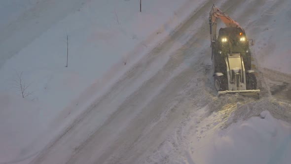 Tractor Cleans the Yard Road From the Snow alt