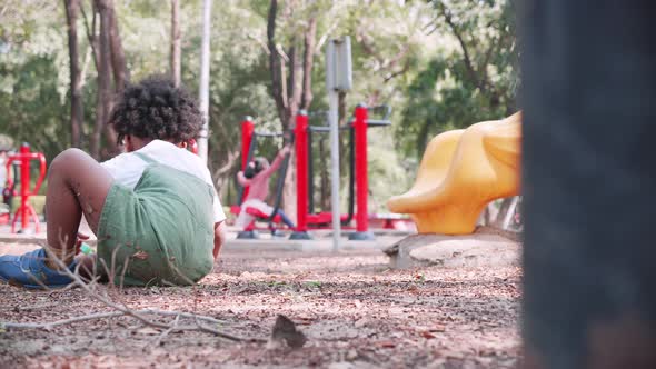 Little boy digging sand in sandbox in playground in park