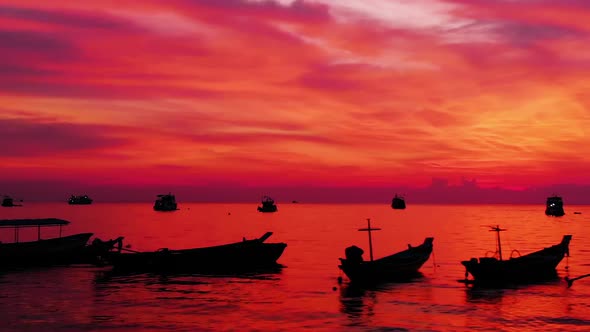 Aerial shot of Koh Tao island, Super sunset at Sairee Beach with many boats floating Thailand alt