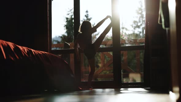 Silhouette Little Girl Talented Dancer Does Ballet Poses Stretching Exercises at Home
