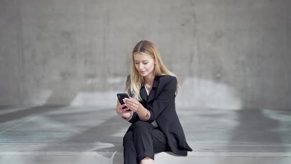 Glad Businesswoman Using Mobile Phone alt