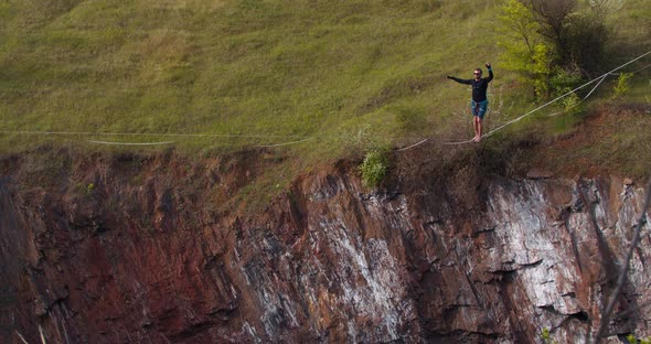 Sportsman Is Slacklining Over a Pit Walking on a Tightrope Extreme Sports alt