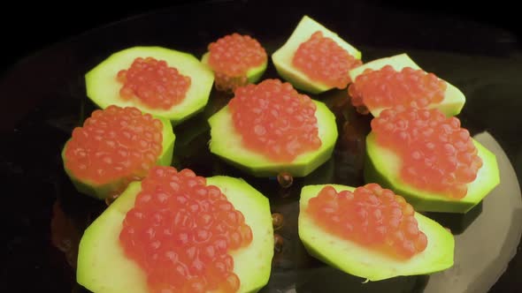 Red Caviar Is Put with a Spoon on Tartlets. Preparation of Snacks with Red Caviar. Top View