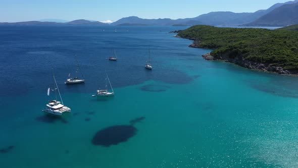 Sailboats, yachts and catamarans anchored on the shores with beach of the islands with vegetation in alt