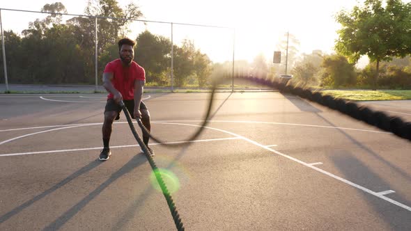 African American man working out with battle ropes alt