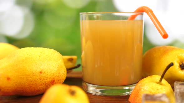 Juice in Glass and Whole and Slice Pear on Table