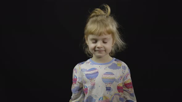 Little Baby Girl in Pajama Going To Sleep. Black Background alt