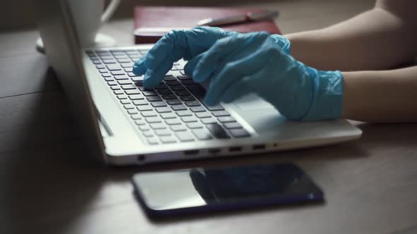 Young Business Man Wears Medical Face Mask Gloves Working on Laptop Computer Sitting at Home Office alt
